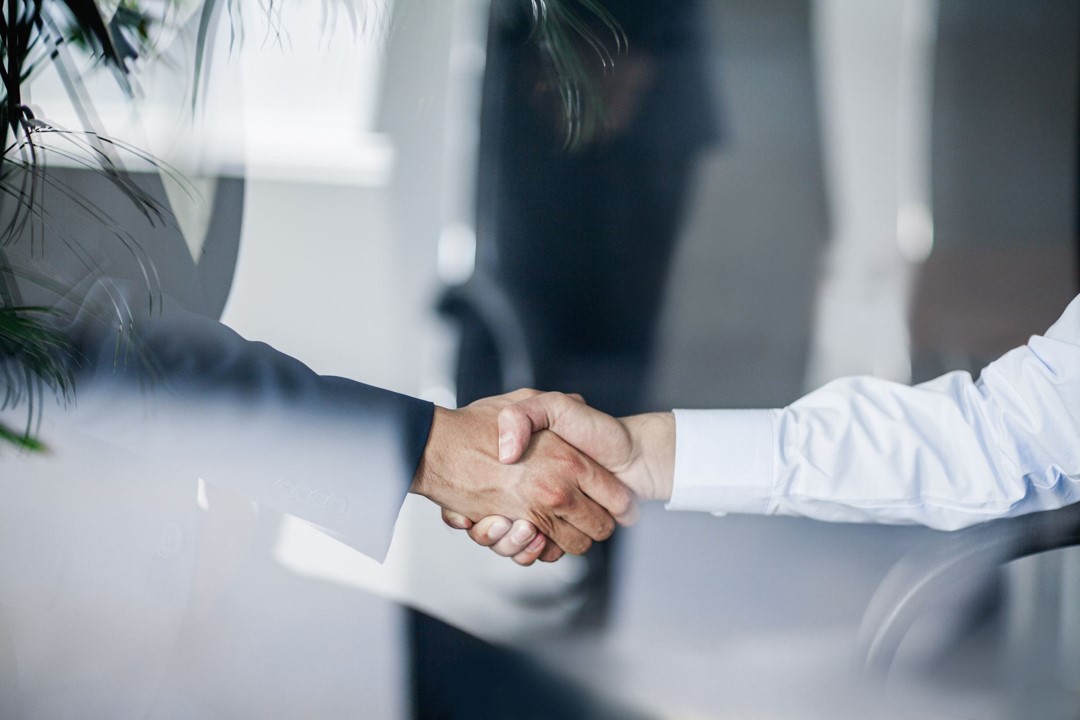 two people in business clothes shake hands